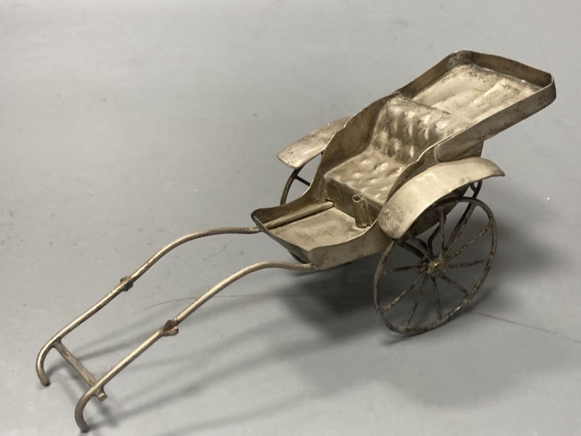 A group of Chinese white metal models of a sampan by Wang Hing, rickshaw and sedan chair etc.